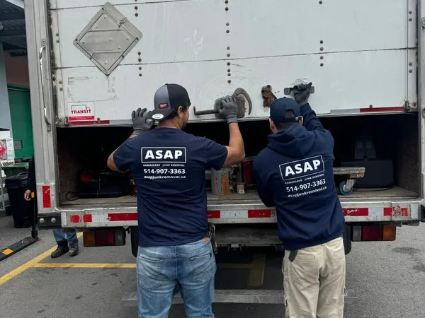 Two ASAP crew members loading a truck, with ASAP logos and phone number on their backs